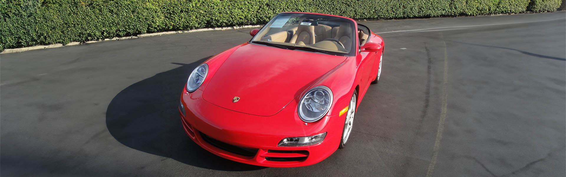 A red Porsche convertible on a sunny day, representing the high-performance sports cars available at Icon Servicing.