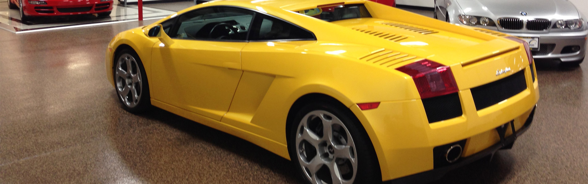 Yellow Lamborghini in the showroom with other high end cars