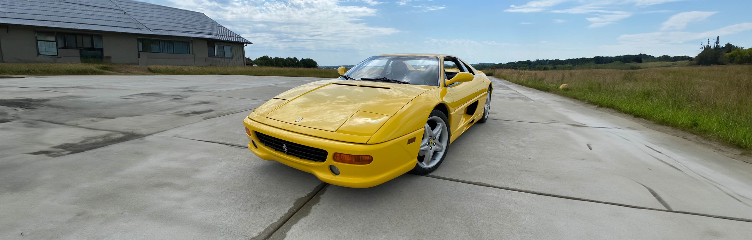 A classic yellow Ferrari on a sunny day, epitomizing the elegance and speed of the cars at Icon Servicing.