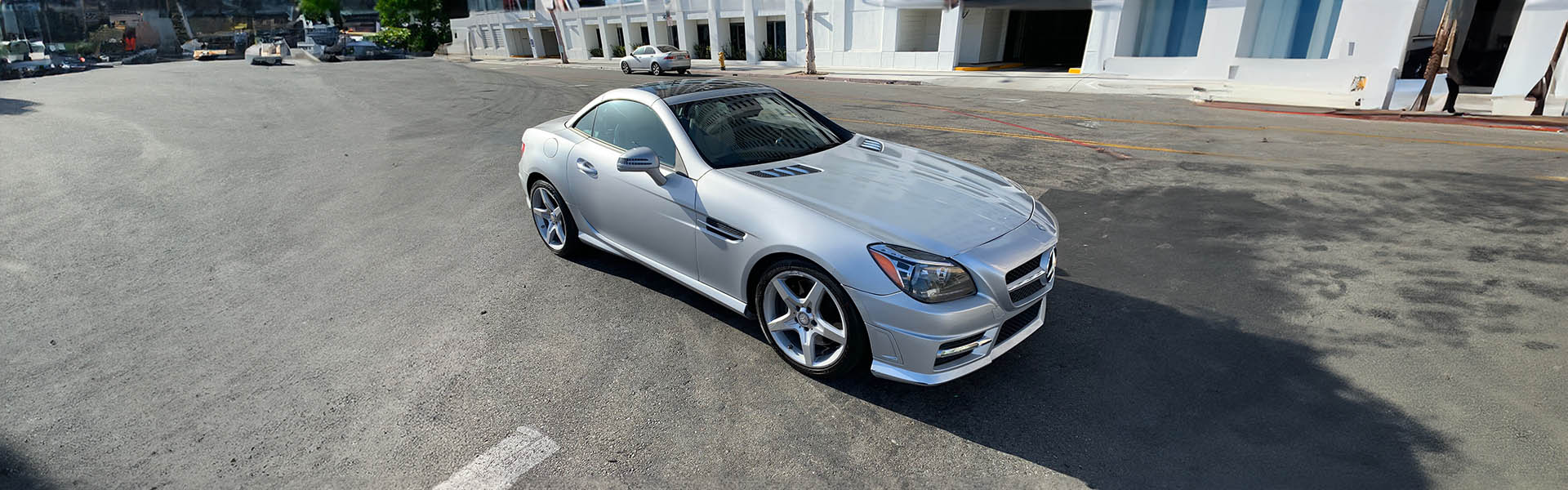 A silver Mercedes-Benz sports car in an urban environment, highlighting the luxury cars featured by Icon Servicing.